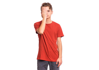 Fototapeta premium Sad handsome teen boy looks with one eye while covering his other eye with his hand, isolated on white background