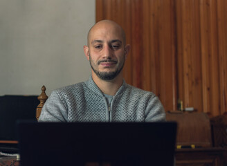 Closeup shot of a male working on his computer from home - new normal concep