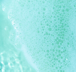 water foam and bubbles of blue color as background. cosmetology concept