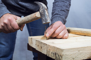 hammering a nail into the board