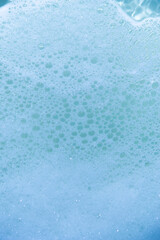water foam and bubbles of blue color as background. cosmetology concept
