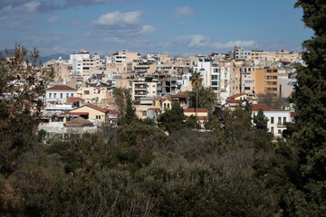 Athens,Attica,Greece  02.09.21 
View of Athens under the Acropolis and the Parthenon. The city emerges between the trees.Blue 