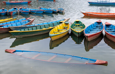 Fototapeta na wymiar Colored tourist wooden boats floating on Phewa lake, Podhara Nepal