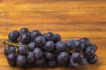Close up view grapes isolated on wooden background.