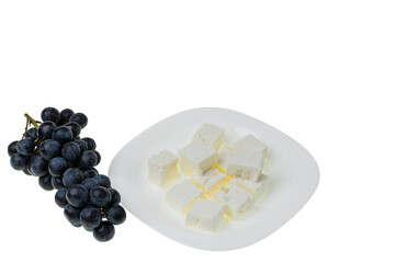 Close up view of black grape and brined white Feta cheese on white background. Healthy eating concept. 