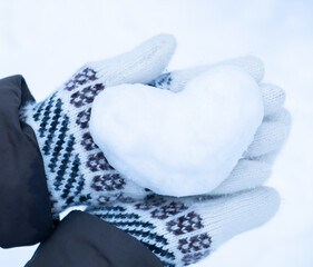 Snowy heart close up in hands. Love symbol for valentine's day and eighth march