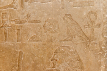 Ancient egyptian hieroglyphs carved on the stone wall