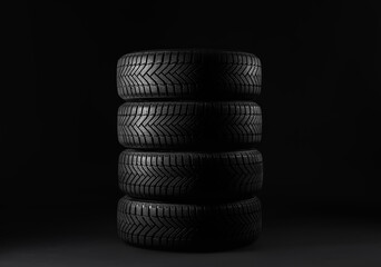 Fototapeta na wymiar Set of new winter tires on black background