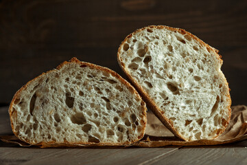 Bread, traditional sourdough bread cut into slices on a rustic wooden background. Concept of traditional leavened bread baking methods. Healthy food.