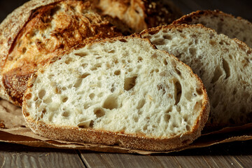 Bread, traditional sourdough bread cut into slices on a rustic wooden background. Concept of...