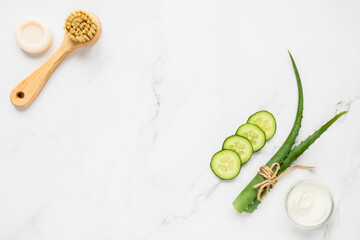 Homemade skin care concept. Green natural ingredients aloe vera, yogurt, cucumber for making a cosmetic mask and brush with soap on a light background.