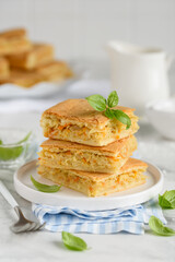 Cabbage pie. Vegetable pastries. Square pieces of pie on a white plate.  Selective focus