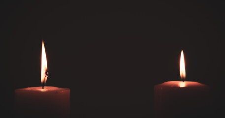 two candles burning in dark