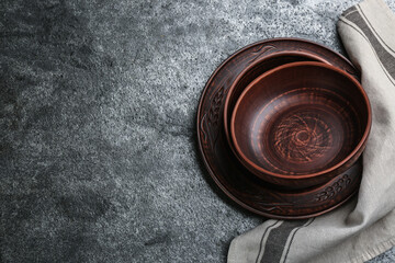 Set of clay dishes on grey table, flat lay. Space for text