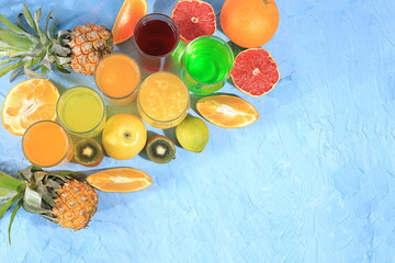 Fruit juice and ingredients, summer tropical drinks on blue table, top view, detox diet and weight loss concept, healthy and natural food, source of vitamin C, selective focus, place for text