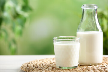 Fresh milk on white wooden table against blurred background, space for text