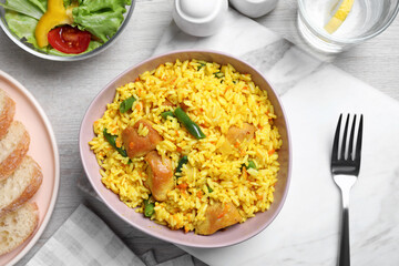Delicious rice pilaf with meat served on table, flat lay