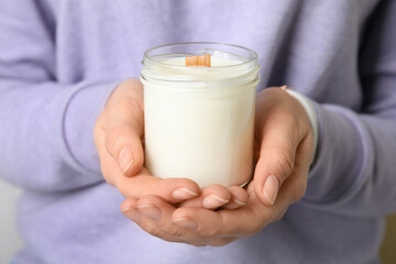 Woman holding candle with wooden wick, closeup