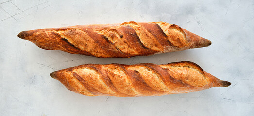 Freshly baked baguette on a light background.