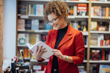 Young woman reading book. Young female student reading book at book store.