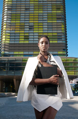 Afro-European business woman in the commercial area of ​​the city under a sunny day doing business