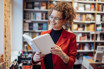 Young woman reading book. Young female student reading book at book store.