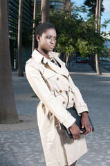 Afro-European business woman in the commercial area of ​​the city under a sunny day doing business