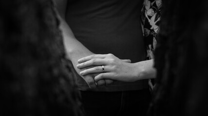 An engaged couple holding hands with focus on the ring