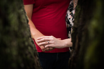 An engaged couple holding hands with focus on the ring