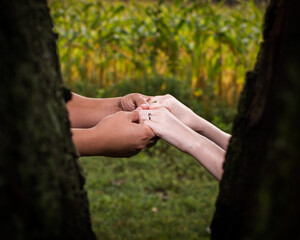 An engaged couple holding hands with focus on the ring