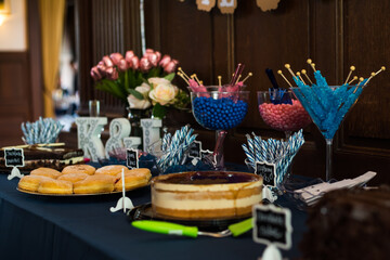 dessert Table at a Party or wedding with lost of blue and pink colors and wooden wall