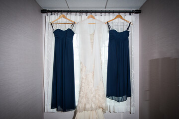Bride's Dress between two blue bridesmaids' dresses