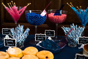 dessert Table at a Party or wedding with lost of blue and pink colors and wooden wall