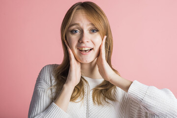 Obraz premium Beautiful young girl on a pink background in the studio cute smiling