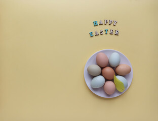Colorful Easter eggs on yellow background. Easter holiday concept, flat lay, top view.