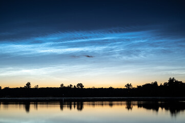 Scenic noctilucent clouds at night sky