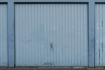 Blue painted and weathered garge door closed, no people and space for text