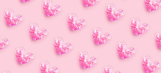 Many hearts with glitter on pastel pink background. Love pattern. Valentines day, birthday holiday decor