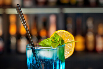 Blue Lagoon cocktail. Blue cocktail on the bar counter. Drink with martini, vodka, rum, tequila and...