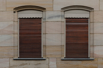 old wooden windows, old wall with two dirty wooden jalousies, shutters closed and rolled up no person and space for text