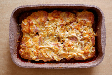 baked meat with cheese in a ceramic mold