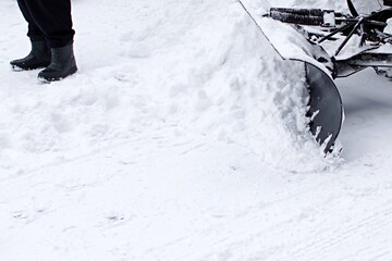 snowblower removes snow from the footpath in the city