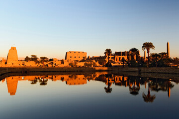 Obraz premium Karnak Temple and the Sacred Lake at sunrise. Karnak was the residence of gods, Amon-Re, his wife Mut, and their son Khonsu, the moon god. Built in the 12th dynasty, 2000 B. C. - 220 B. C.