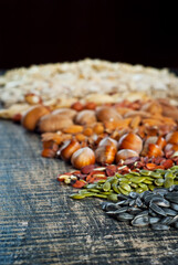 Many kinds of nuts close up. Heap of nuts on a black wooden board. Nuts are stacked on the table.