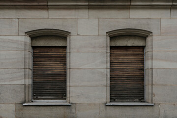 old wooden windows with shutters, brick wall with two closed windows, space for text, no person
