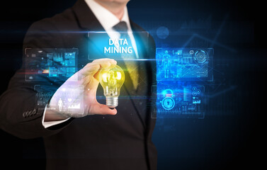 Businessman holding lightbulb with DATA MINING inscription, online security idea concept