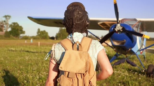 Woman Pilot Portrait Walking To Her Small Airplane At Summer Sunny Weather. Active Female Flier Doing Sport. Aircraft And Technology Concept. Retro Vintage Style.