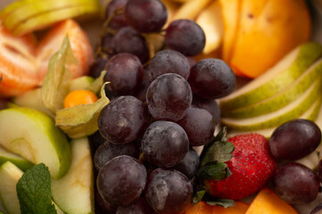 Naklejka na ściany i meble Background from sliced ​​fruits, apples, pears, strawberries, grapes, persimmon, orange.