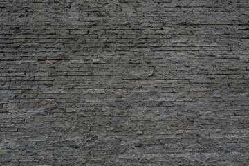 Grey brick stone wall with cracked and uneven background, space for text, no people and horizontal