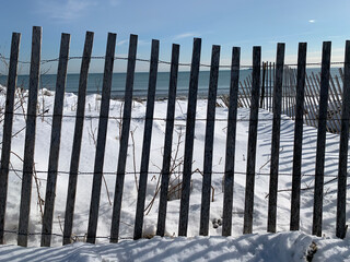 Vistas del camino y la playa nevados al borde del mar en un día  soleado y muy frio